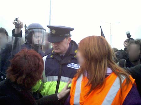 garda surrounded as he tries to move a woman in a wheelchair