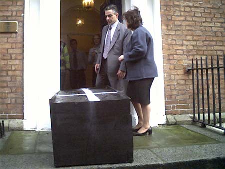 greek diplomats look at coffin