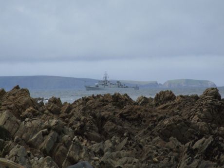 Over the rocks what can we see? A boat from Ireland's Navee