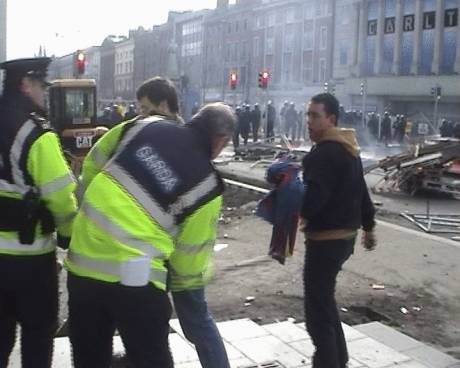 Garda swinging a baton at demonstrator