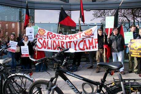 Protestors stand behind a barrier of their own bicycles