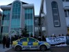 Protestors gather in solidarity outside Raytheon, while nine women (centre of picture) sit inside chained to an internal door.