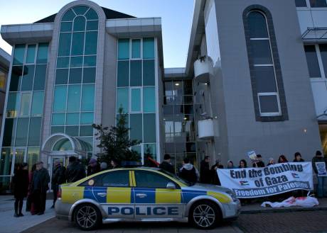 Click on image to see full-sized version Protestors gather in solidarity outside Raytheon, while nine women (centre of picture) sit inside chained to an internal door.