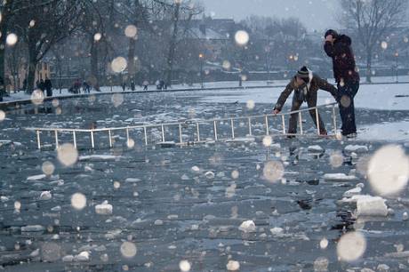 Click on image to see full-sized version Ice skaters on the frozen lough put a ladder from the ice over water to the surrounding wall so that they can climb across and onto land