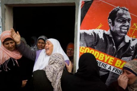 The mother of Jawaher Abu Rahmah (center) mourns during her daughter's funeral on 1 January. On the right is a poster of Bassem Abu Rahmah, her other son who was killed in 2009. (Oren Ziv/ActiveStills)