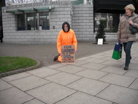 Colm kneels as detainee