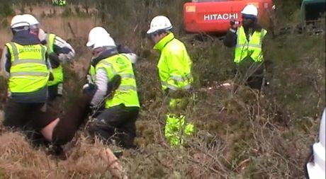 Hauling protestors out over the woods and boggy ground