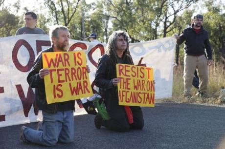 Click on image to see full-sized version Veteran members of the Catholic Worker movement Jim Dowling and Ciaron O'Reilly blockade military vehicles by kneeling in Nonviolent Resistance to the Talisman Sabre War Games Exercise