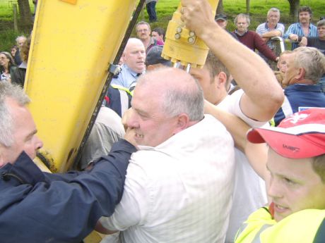 Police try to pull Willie Corduff off the digger. 