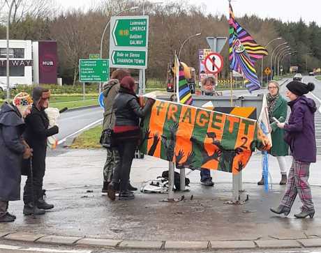 Some suffragettes suffering in the wind and rain at the Shannon protest against the killing of women and children in US resource wars