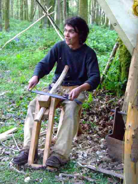 Shaping a leg on the shave-horse with a drawknife.