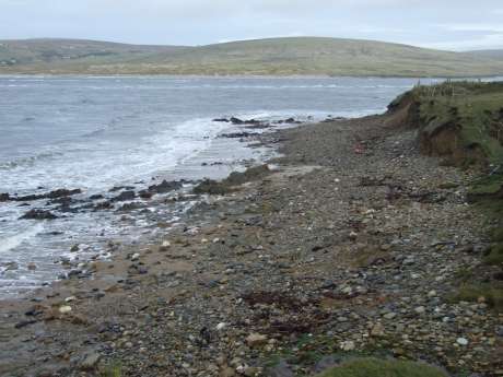 Imported and/or excavated stone and rubble left lying on the sand.