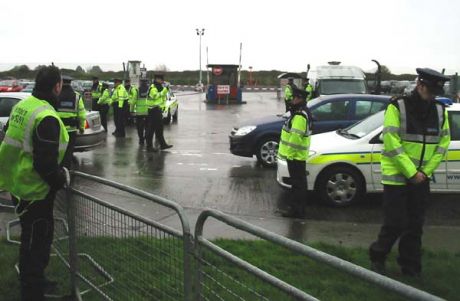 Wet Gardai at Shannon protect their "essentials" watched by Conor Cregan