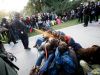 In this Friday, Nov. 18, 2011, photo University of California, Davis Police Lt. John Pike uses pepper spray to move Occupy UC Davis protesters while blocking their exit from the school's quad Friday in Davis, Calif. Two University of California, Davis pol